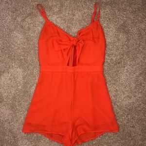 Orange romper with a tie in the front